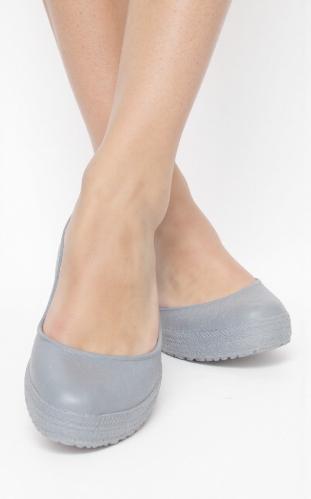 A female model wearing rubber shoes, against a white background, with a close   up of the feet